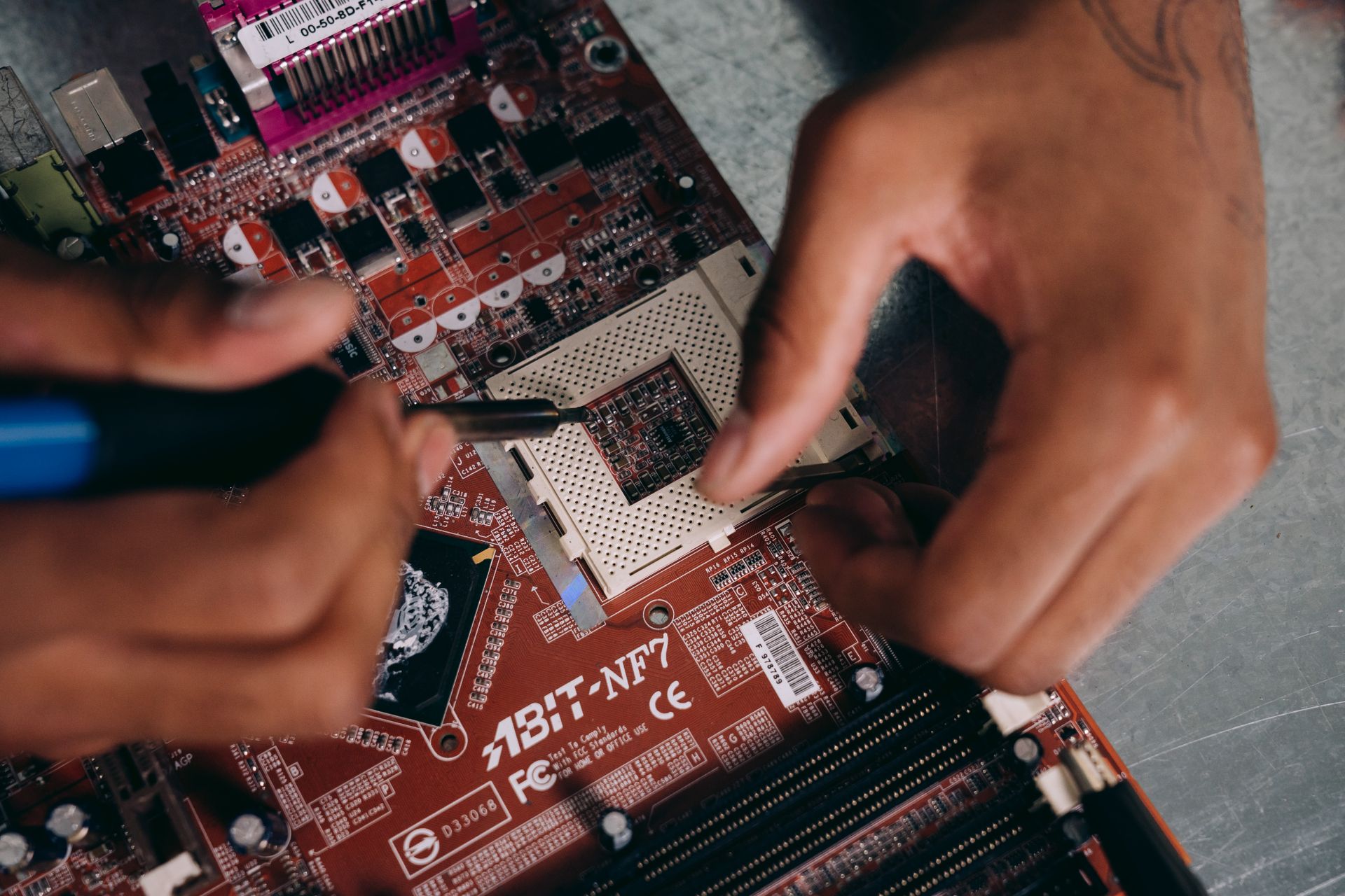 Close-up Photo of Motherboard being fixed by a Person