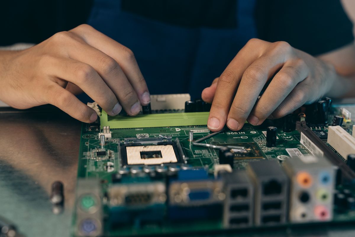 Technician's hands assembling a computer motherboard
