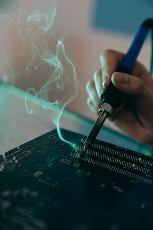 Close-up Photo of Motherboard being fixed by a Person