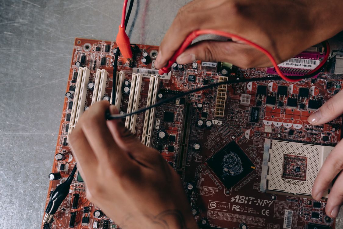 Técnico trabalhando em placa de computador durante reparo eletrônico