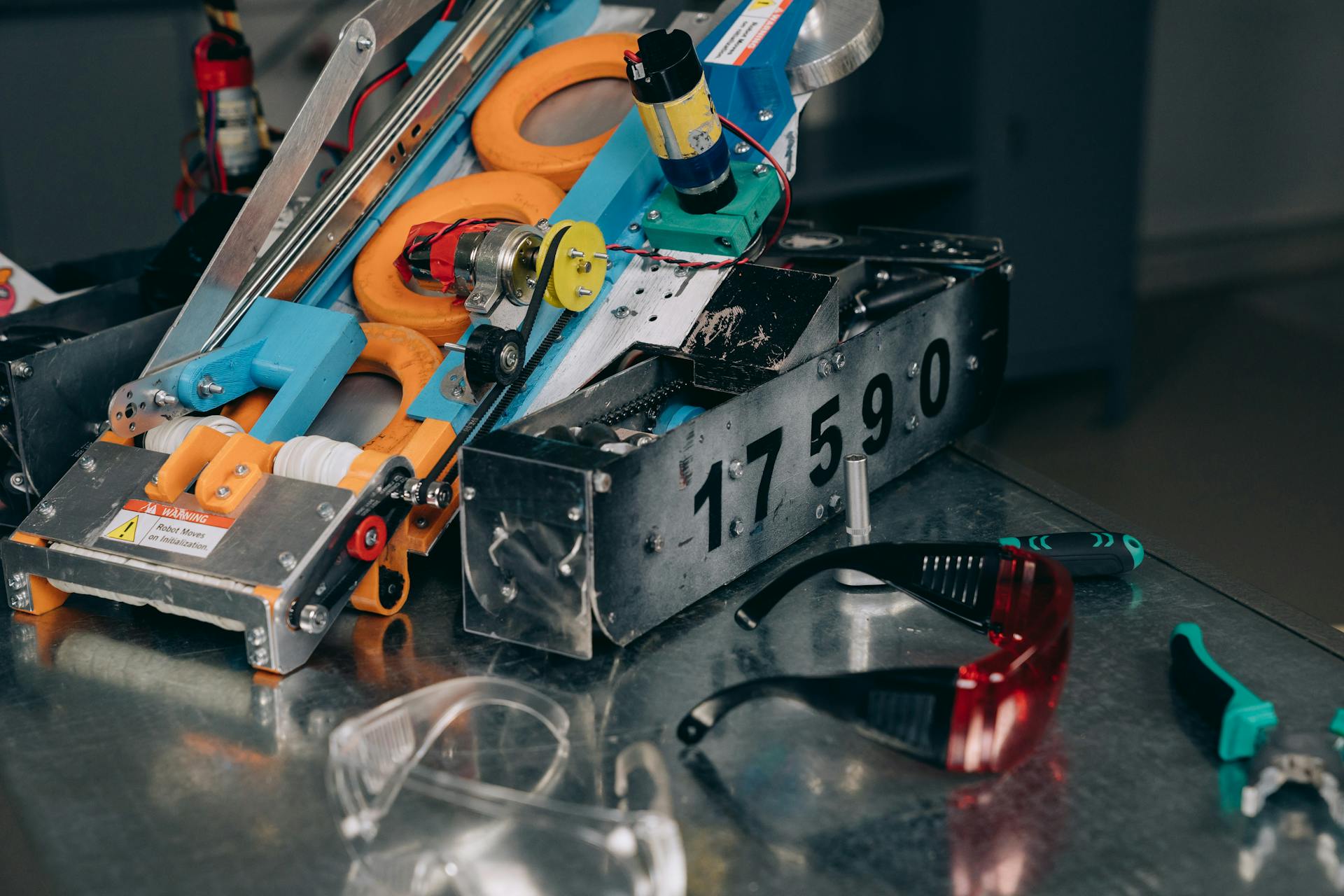 Steel Machine Equipment Beside Safety Glasses on a Metal Surface