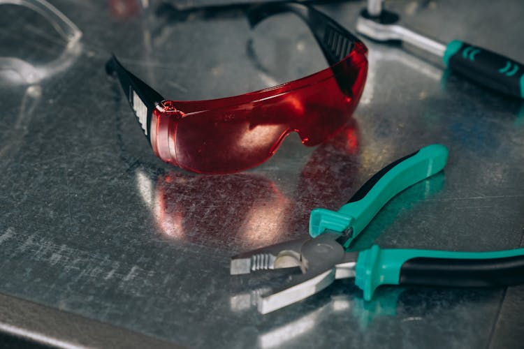 Close-up Photo Of Pliers And Protective Goggles