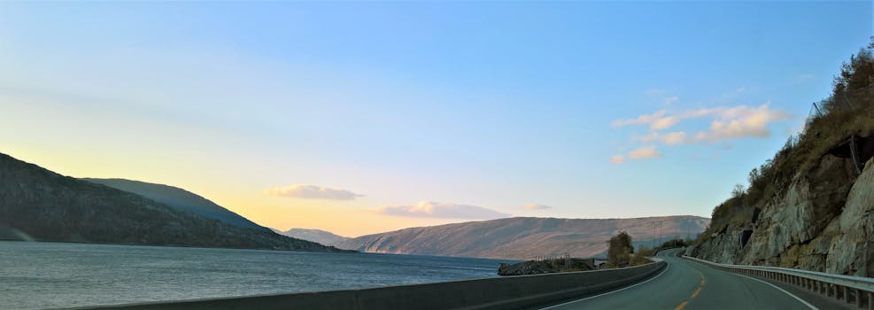 Beautiful landscape of a coastal road in Hol, Norway during sunset with mountains and sea.