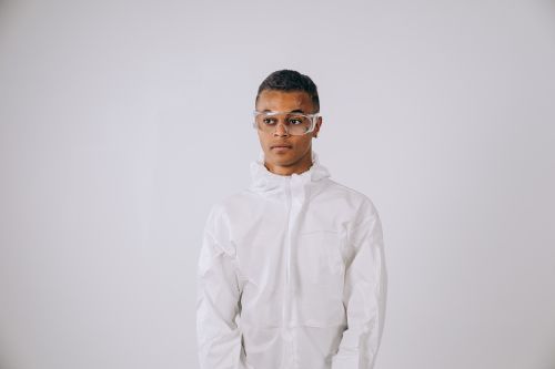 Free Young scientist wearing protective gear in a studio setting, ready for research. Stock Photo