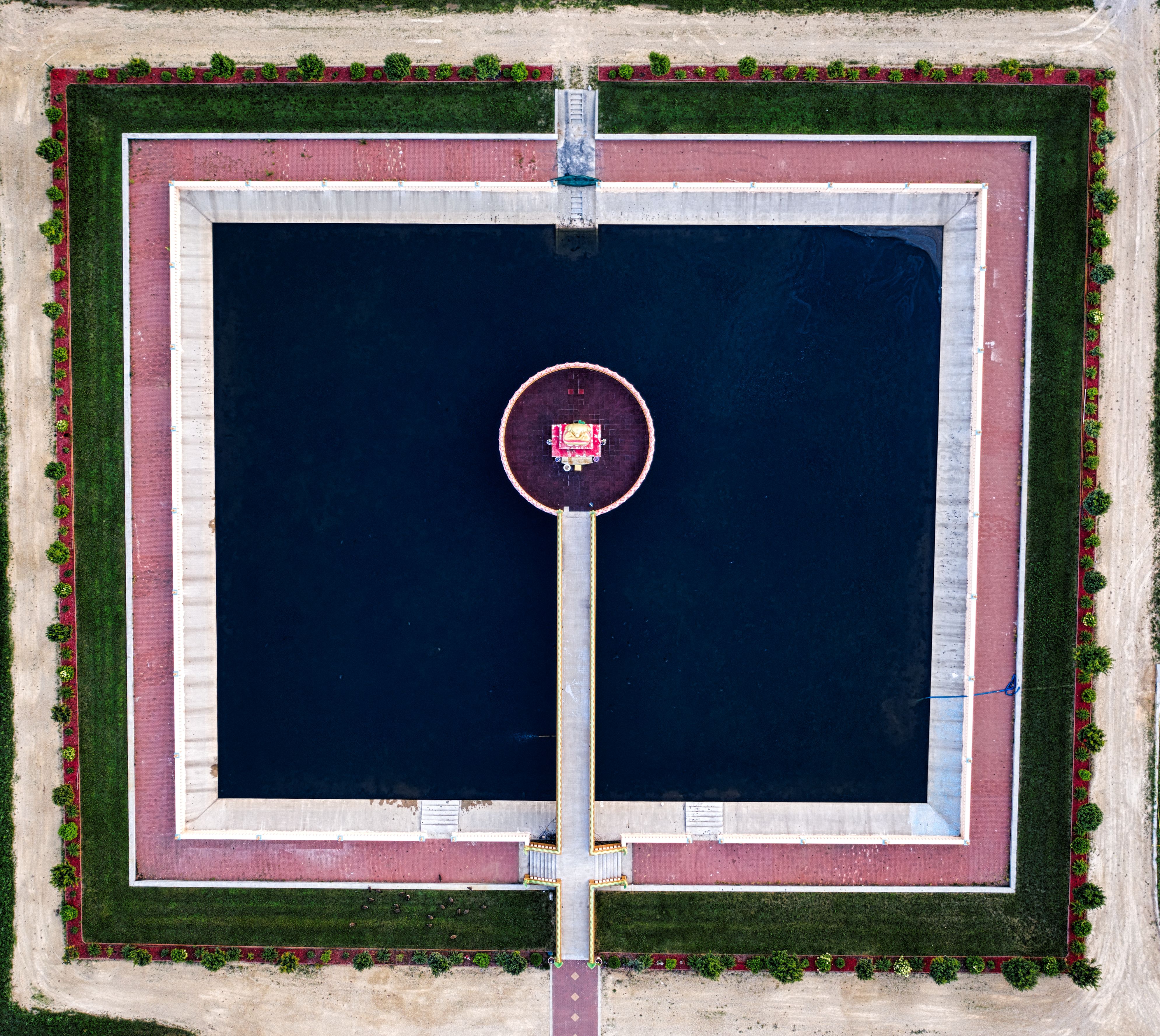 A stunning aerial view of a modern geometric pond with a central structure in Hampton, MN.