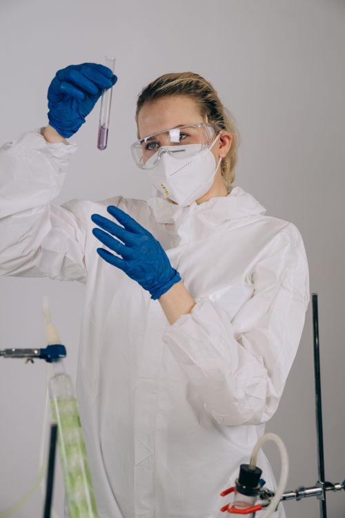 Free Scientist in protective gear analyzing a sample in a laboratory setting. Stock Photo