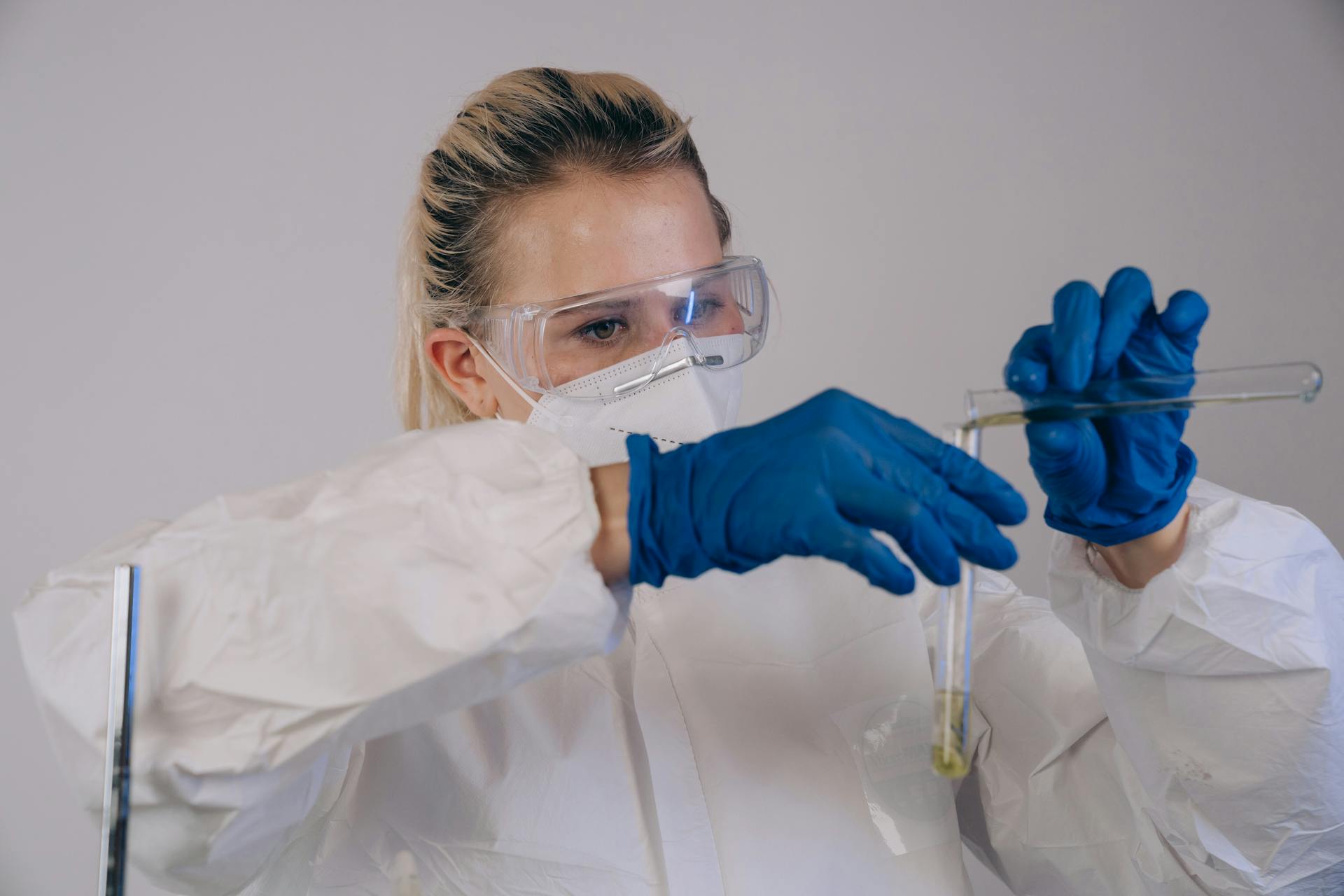 A Scientist Transferring Test Tube on Another Test Tube