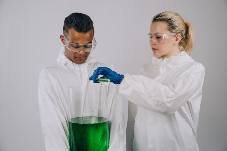 Woman Pouring Chemical On A Large Beaker