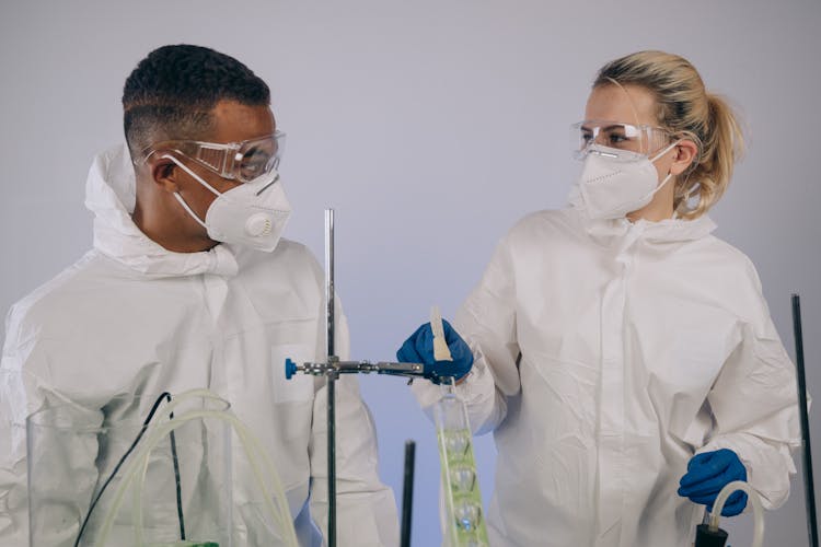 Chemists Wearing Facemasks Doing A Science Experiment