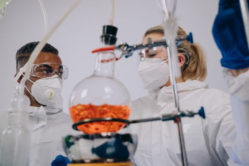 Free Two scientists in PPE conducting experiments with lab equipment, focusing on chemical reactions. Stock Photo