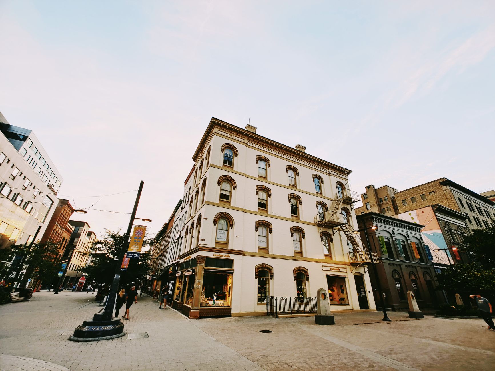 Low angle view of a historic building in Ithaca's downtown area with people walking nearby.