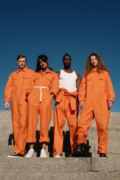 Free A Group of People Wearing Orange Jumpsuit Standing on Gray Steps
 Stock Photo