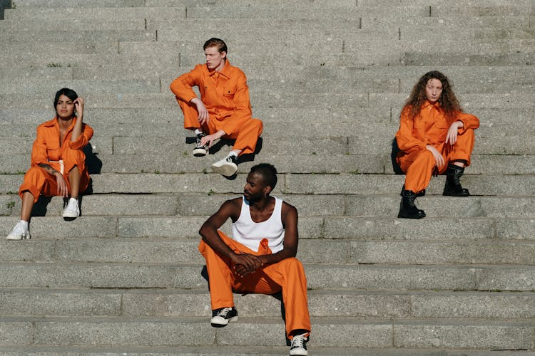 A Group Of Prisoners Sitting On The Stairs