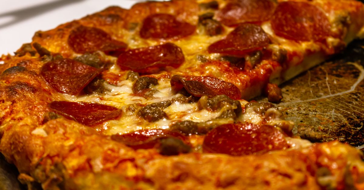Pizza de pepperoni suculenta com queijo derretido e cogumelos, pronta para comer.