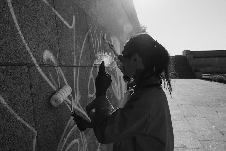 A Man Smoking And Holding A Paint Roller