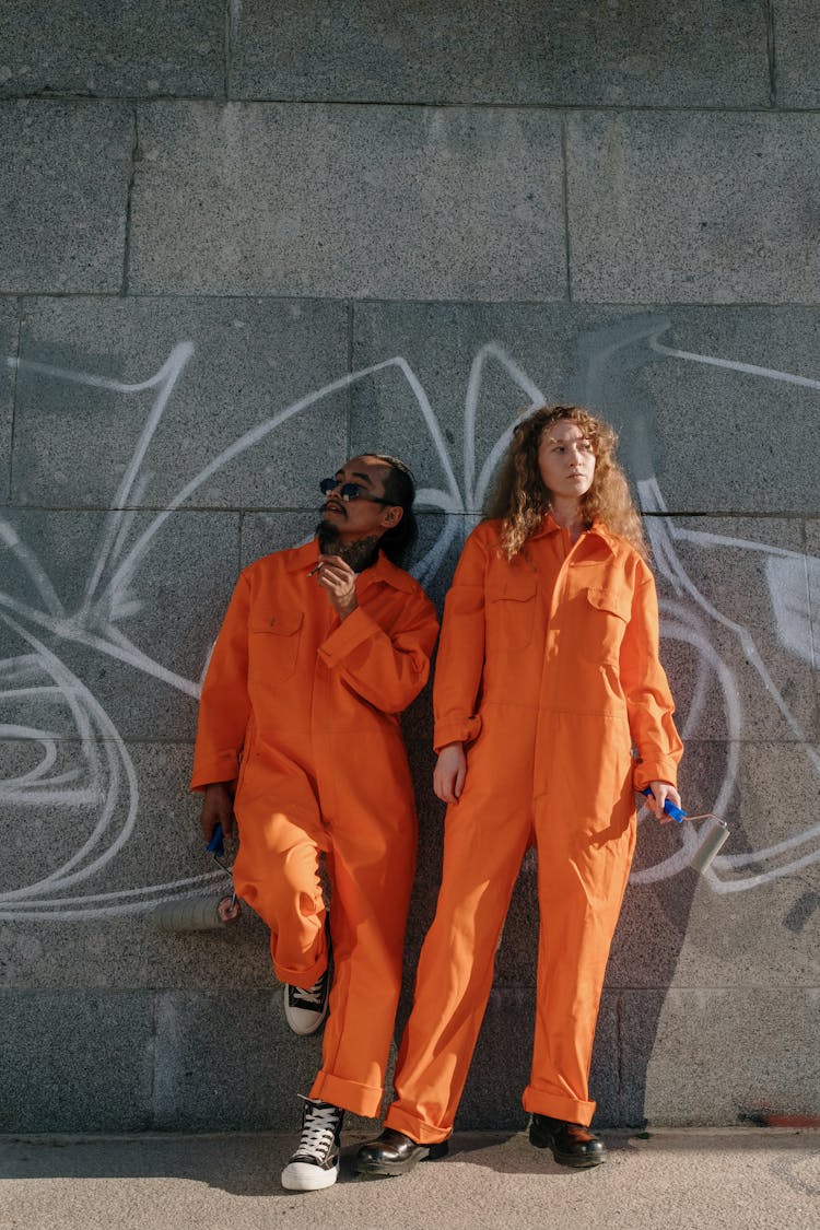 Convicts Standing By A Wall With Graffiti