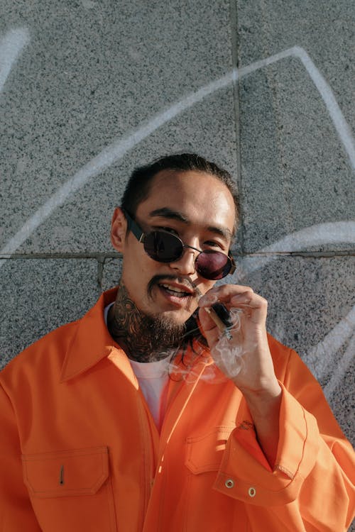 Man in Orange Jumpsuit Smoking a Cigarette