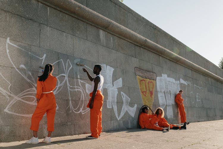 A Group Of Prisoners Painting A Wall