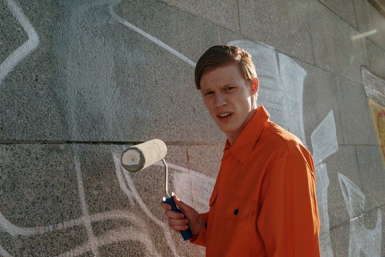 A Man Painting A Wall