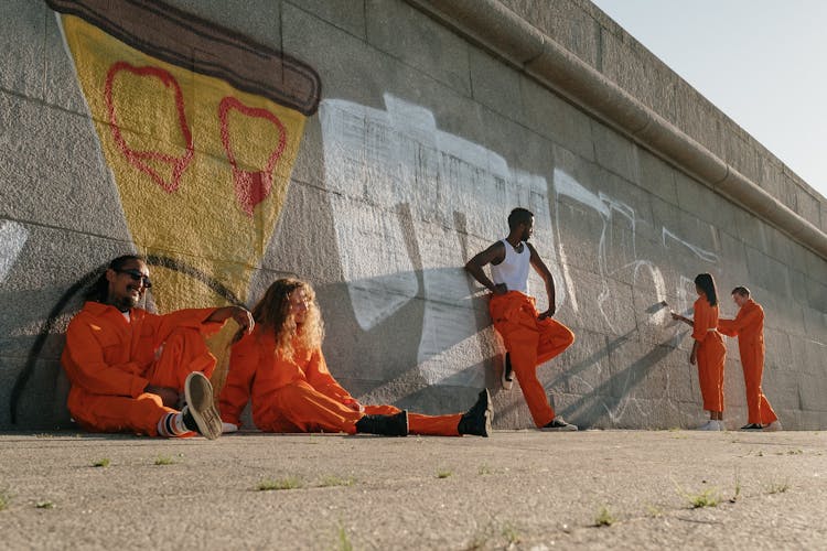 A Group Of Prisoners Painting A Wall