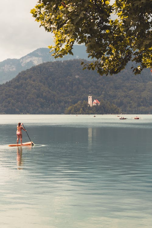 A Person Paddle Boarding in Lake Bled