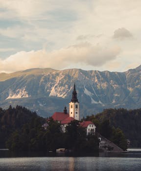 Serene view of picturesque church on Lake Bled with majestic mountains in Slovenia.