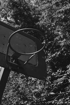 Close-up of a basketball hoop in black and white outdoors.