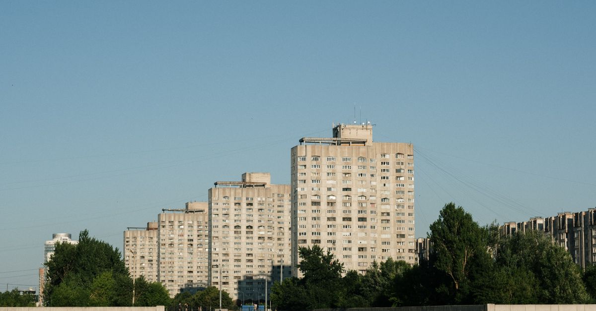 Contemporary apartment buildings along a serene canal in Saint Petersburg, Russia.