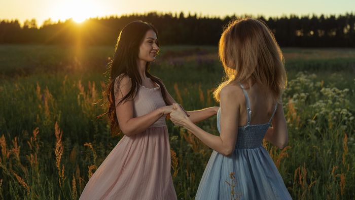Two friends in a sunlit field at sunset, by Alexey Turenkov on Pexels