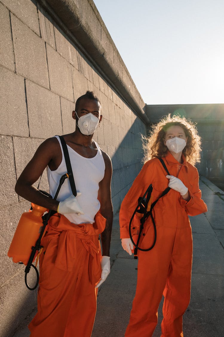 Convicts In Face Masks Holding Pressure Sprayers