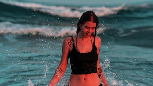 Woman in Black Tank Top Standing in the Ocean