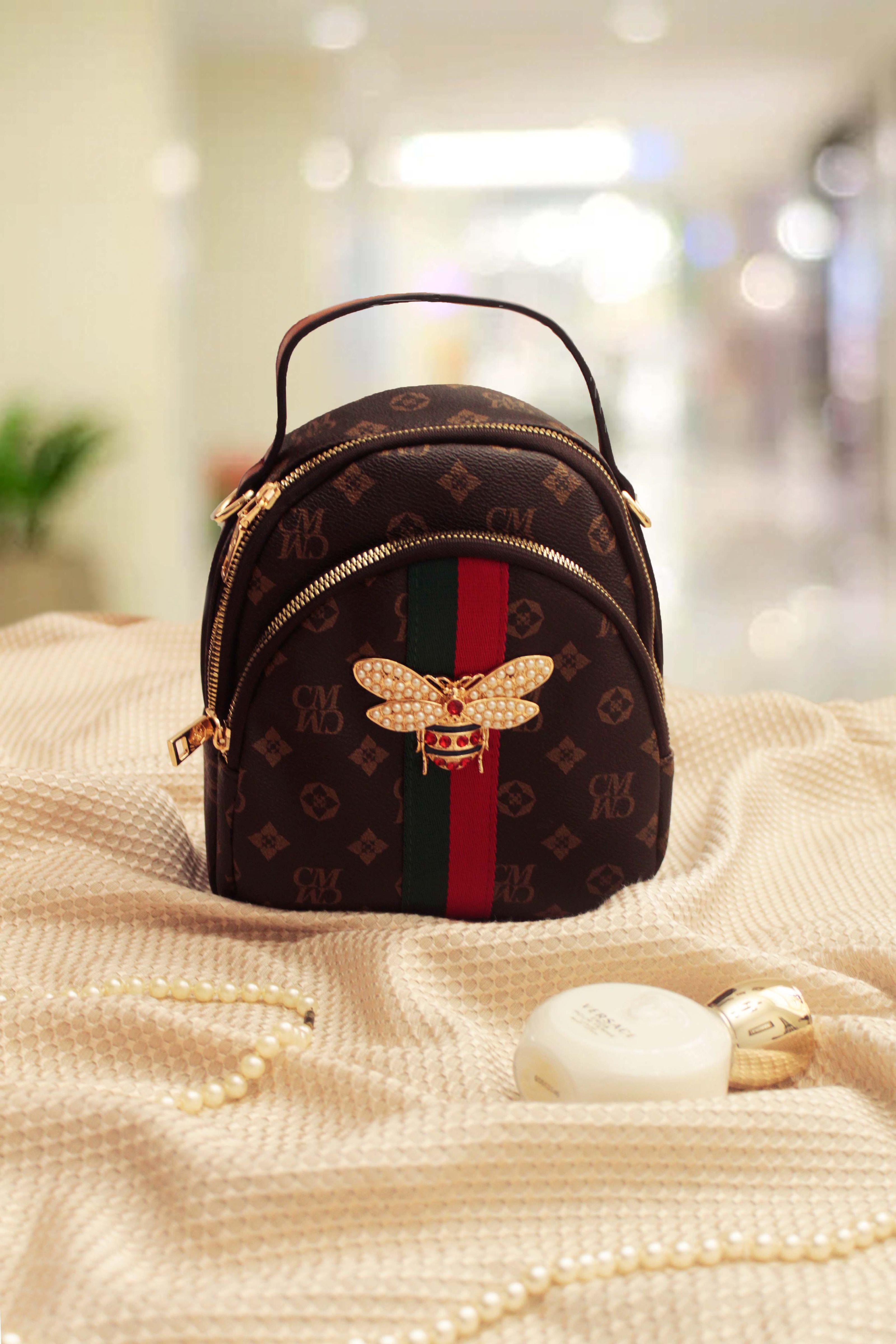 Close-up de uma bolsa de designer de luxo com detalhes em dourado exibida de forma estilosa em uma loja.