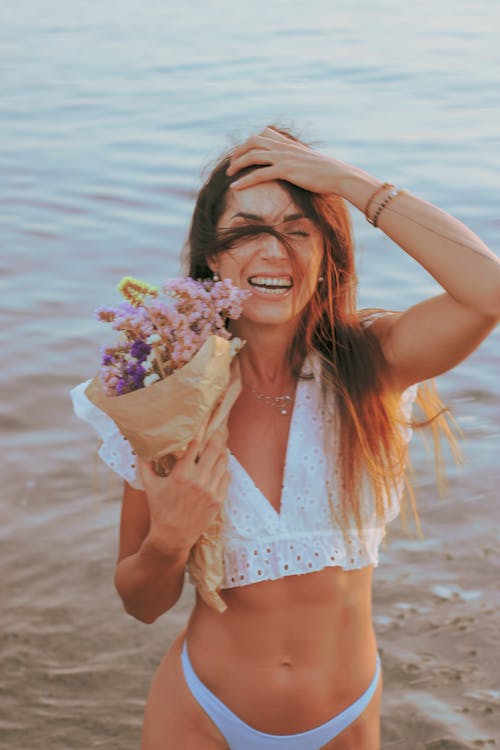 Gratis lagerfoto af blomsterbuket, holde, hvid bikini