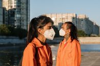 Woman in Orange Coat Wearing White Mask