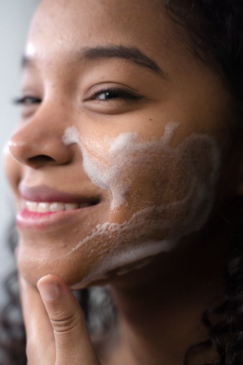 Free A close-up portrait of a woman applying face wash, highlighting her skincare routine. Stock Photo