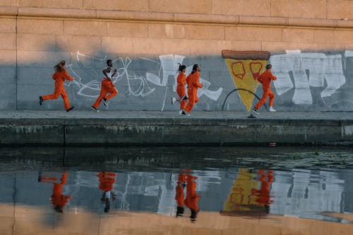 Free Inmates Running by a Wall with Graffiti Stock Photo