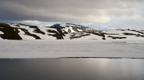 Free Peaceful winter scene showcasing snow-capped mountains and a frozen lake. Stock Photo