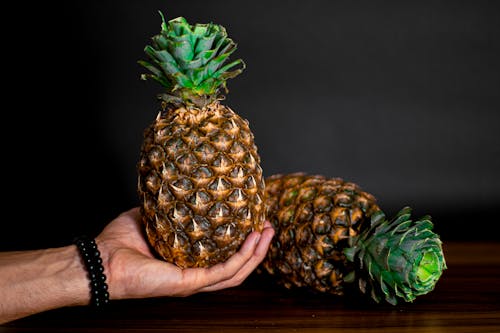 Close-Up Shot of a Person Holding a Pineapple