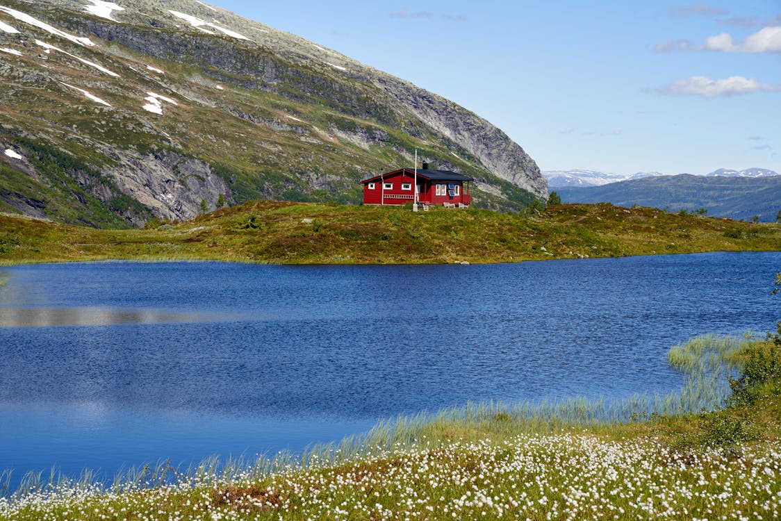 Free Red and Black House Near Lake and Mountain Stock Photo