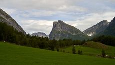Green Grass Field Near Green Mountain Under White Clouds