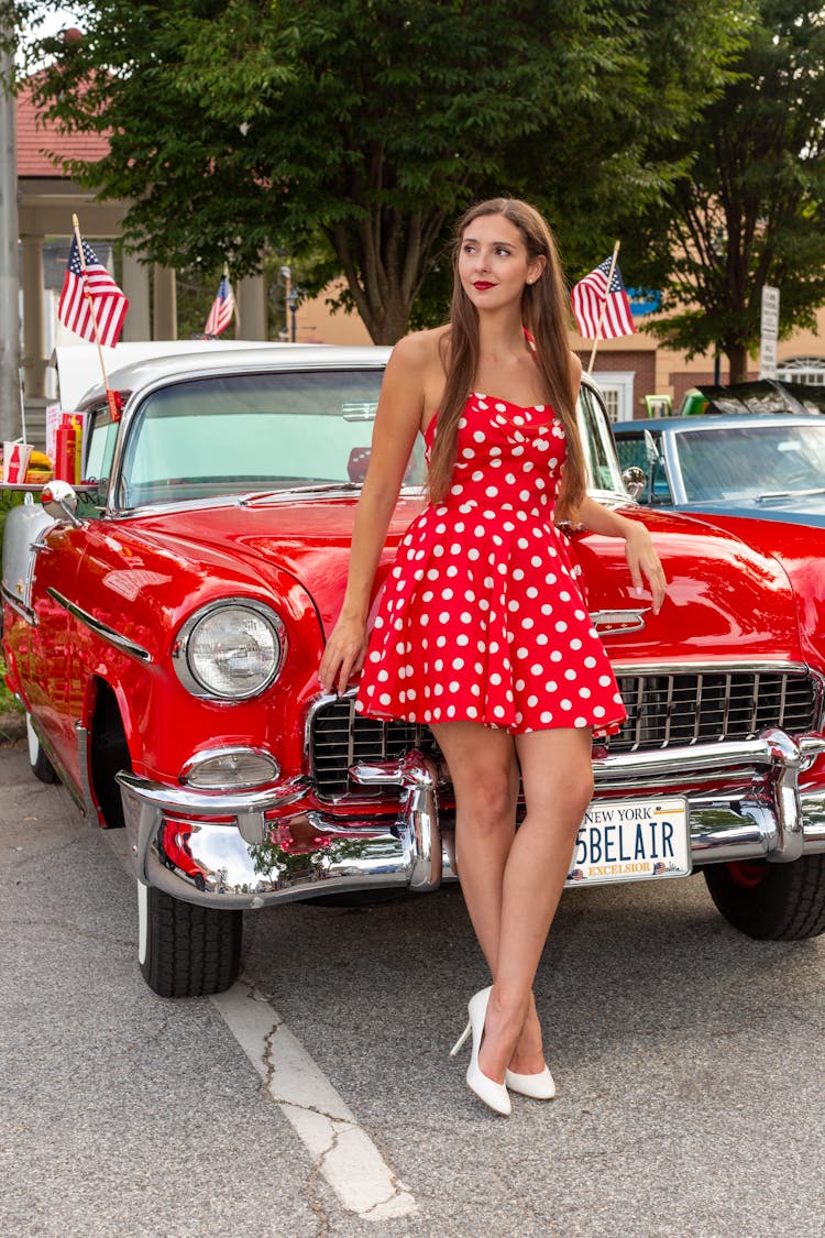 Woman In Polka Dot Dress Standing Next To A Retro Chevrolet Bel Air 