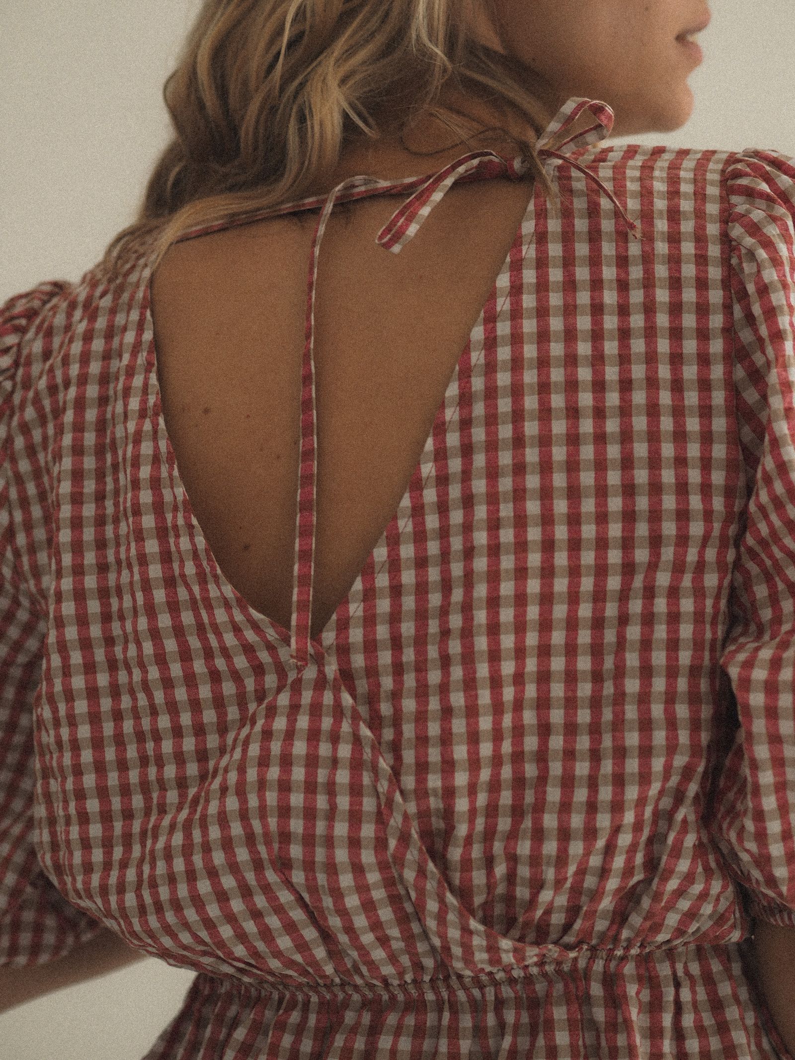 A woman in a red and white plaid dress