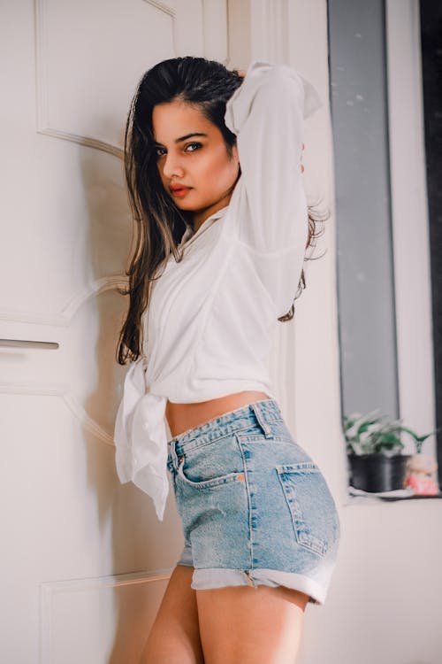 Beautiful Woman in Denim Shorts Posing with Her Hand on Her Head