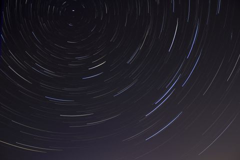 Milky way and stars above a dark mountain ridge