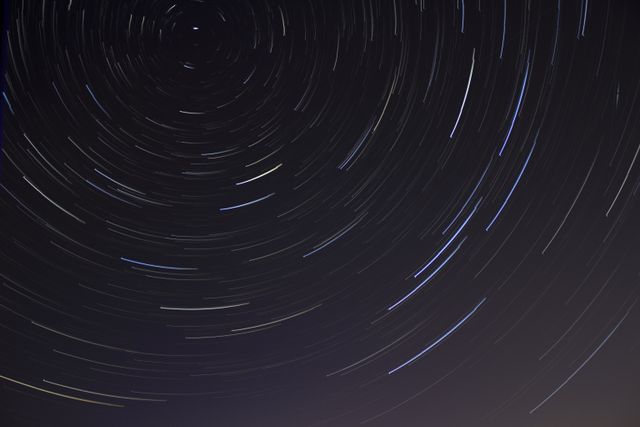 Star-filled night sky above dark hills