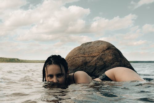 Free Woman in Black Bikini Lying on Water Stock Photo