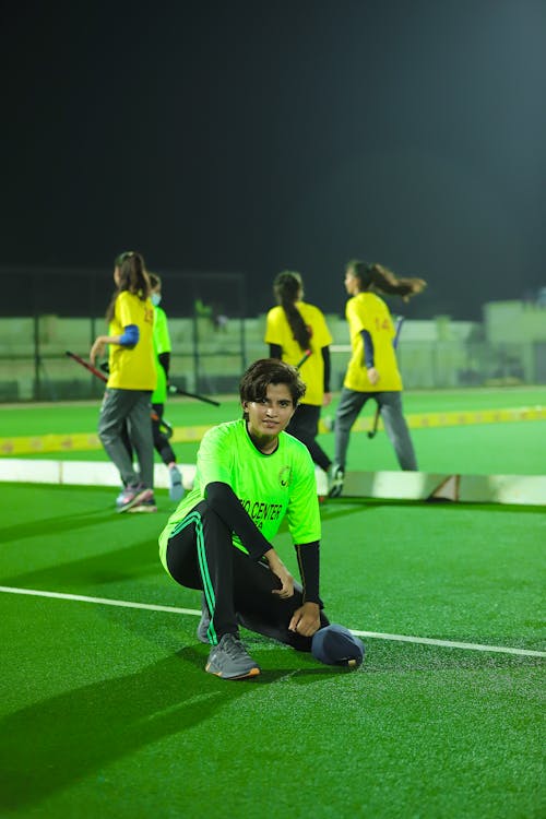 Woman crouching on artificial grass