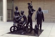 Man and Woman Sitting on Black Metal Chair Statue