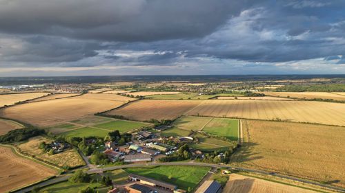 Free Scenic aerial shot of farmland and countryside in Chapel End, UK under cloudy skies. Stock Photo