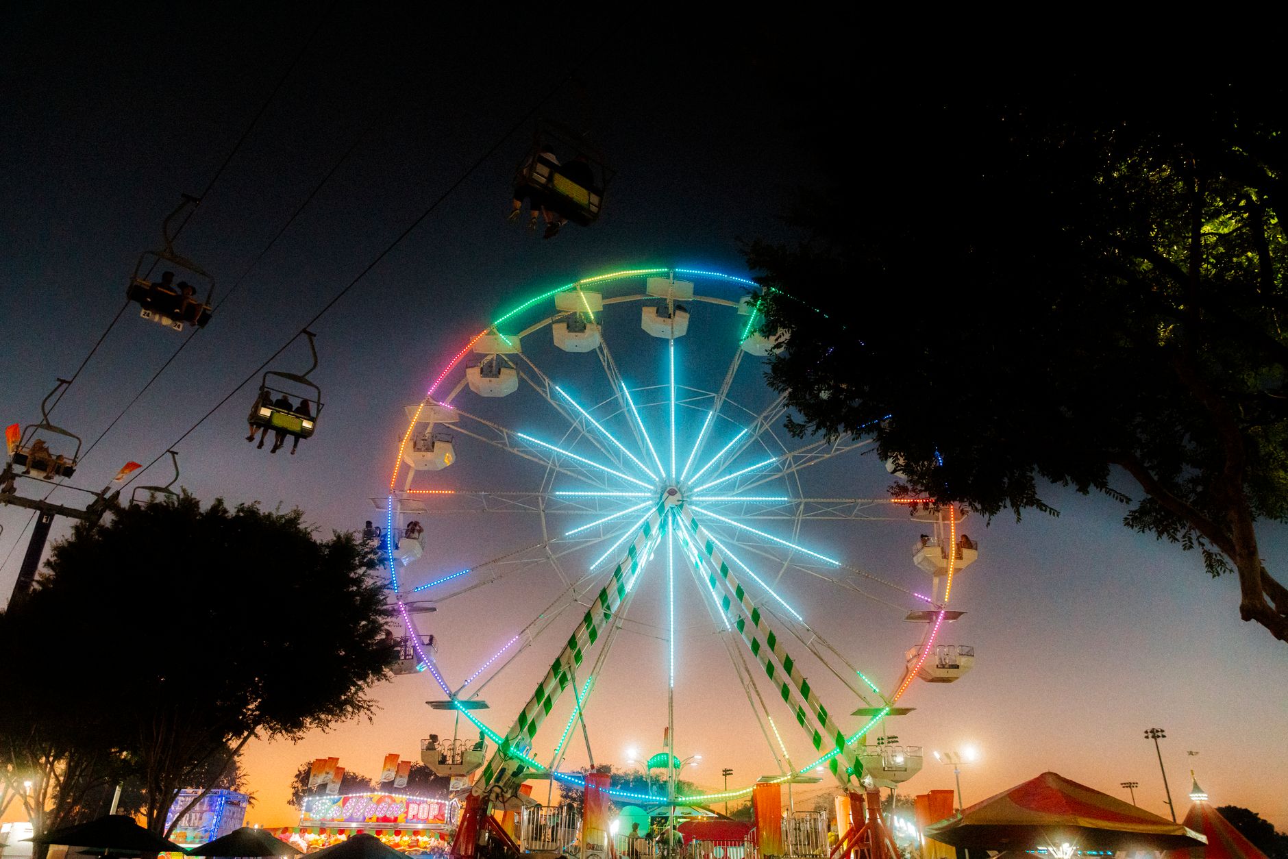 Robertson County Fair midway at dusk with lit rides and a Ferris wheel